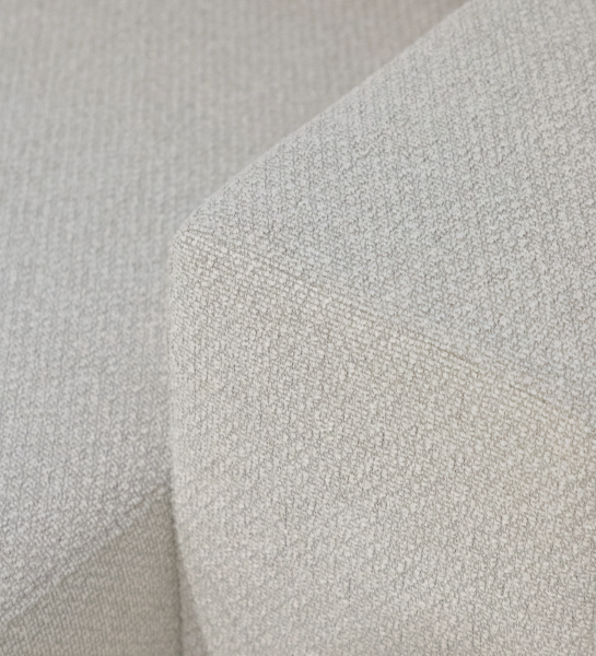 Detalle de tejido beige en esquina del sofá con chaise longue