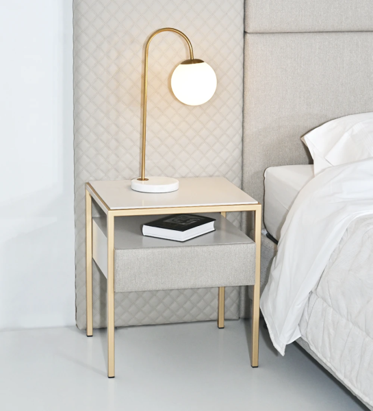 Bedside table with 1 drawer with fabric upholstered front, pearl lacquered top and drawer module, gold lacquered metal foot.